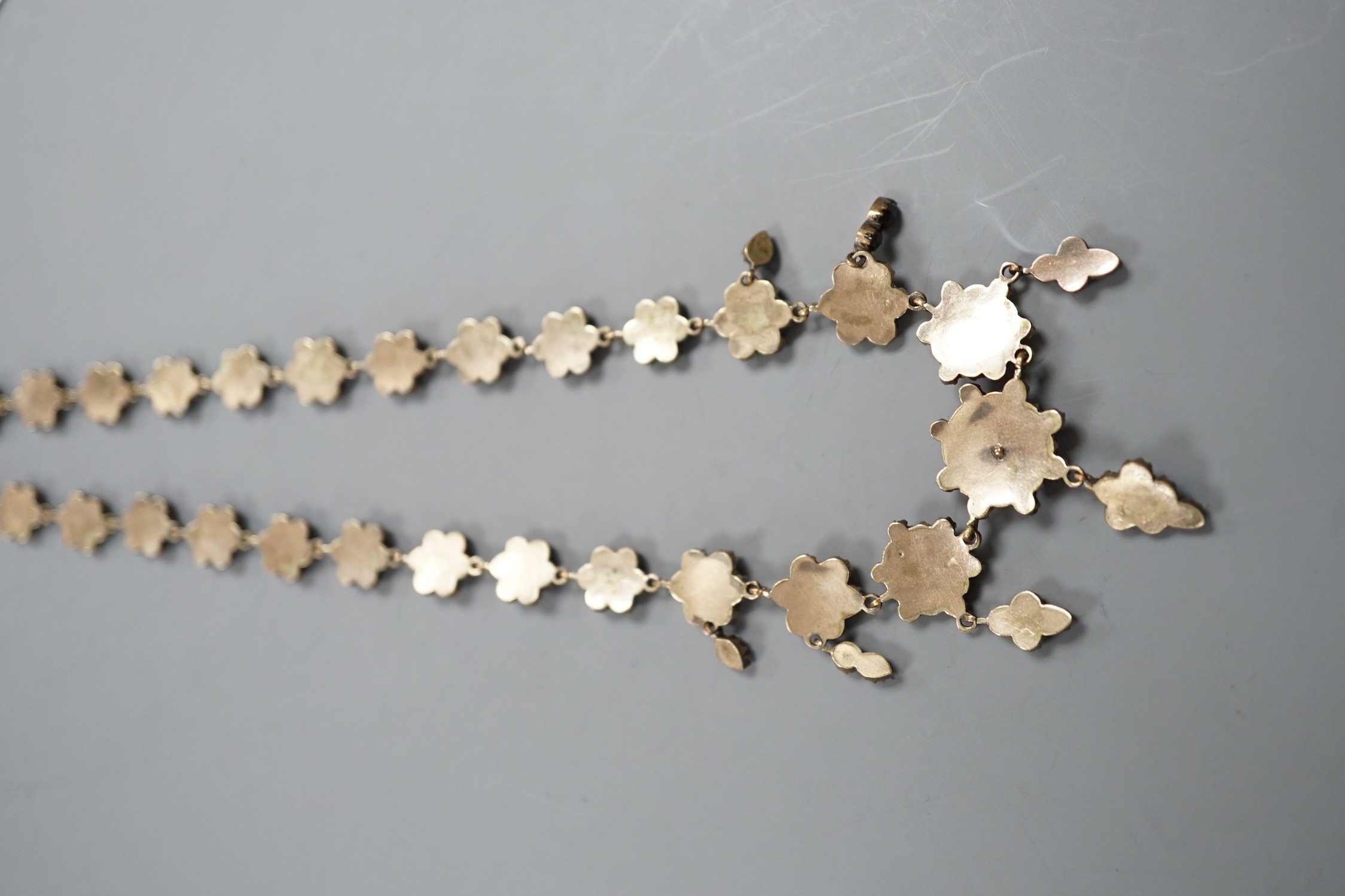 A late Victorian gilt and yellow metal, garnet cluster set drop necklace, 48cm.